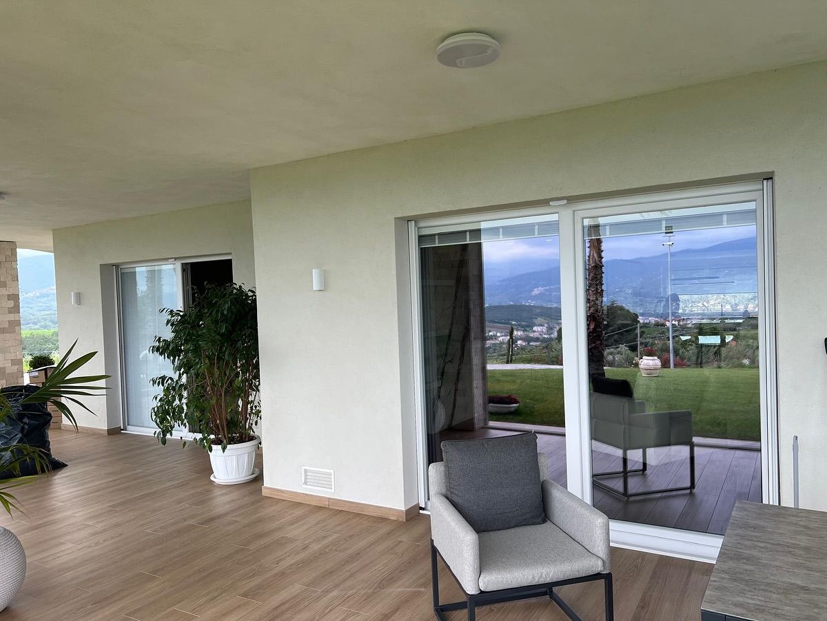 Un soggiorno con una sedia, un tavolo e porte scorrevoli in vetro.