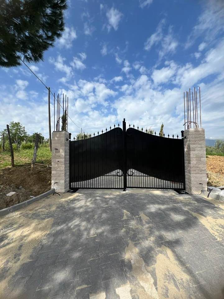 Un cancello nero con un cielo blu sullo sfondo