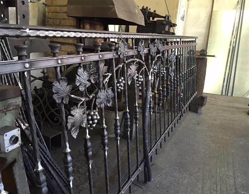 Una ringhiera in ferro battuto con uva e foglie sopra