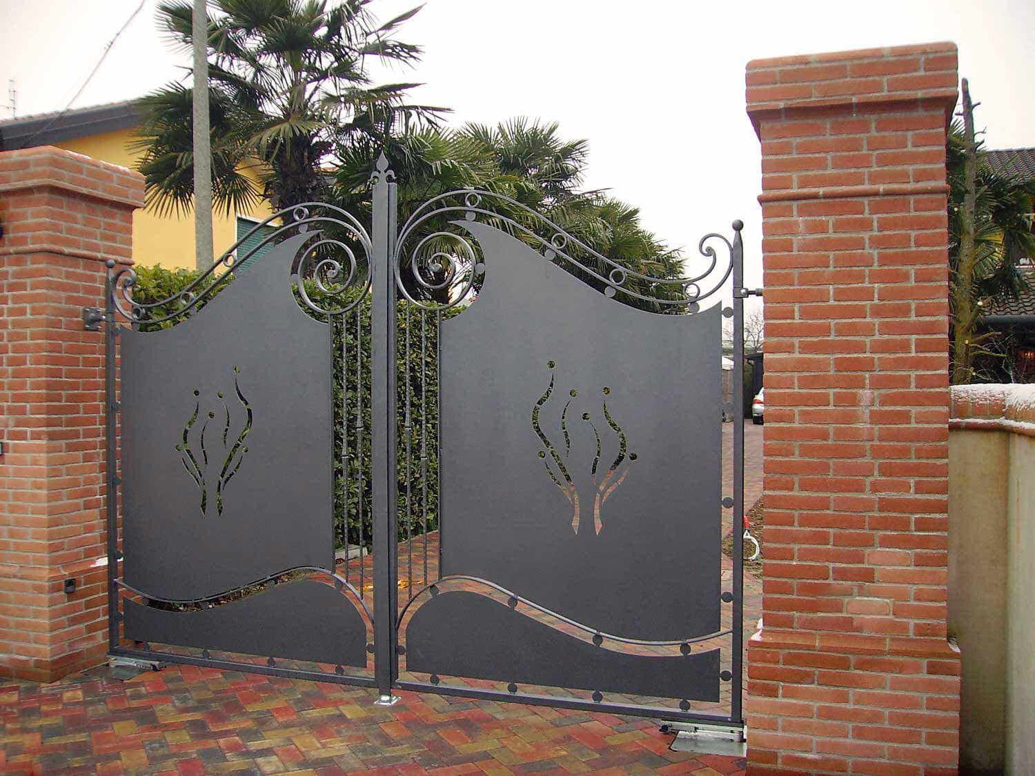 Un cancello in ferro battuto è circondato da pilastri in mattoni