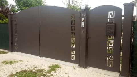 Una recinzione con un cancello e una cassetta della posta di fronte.