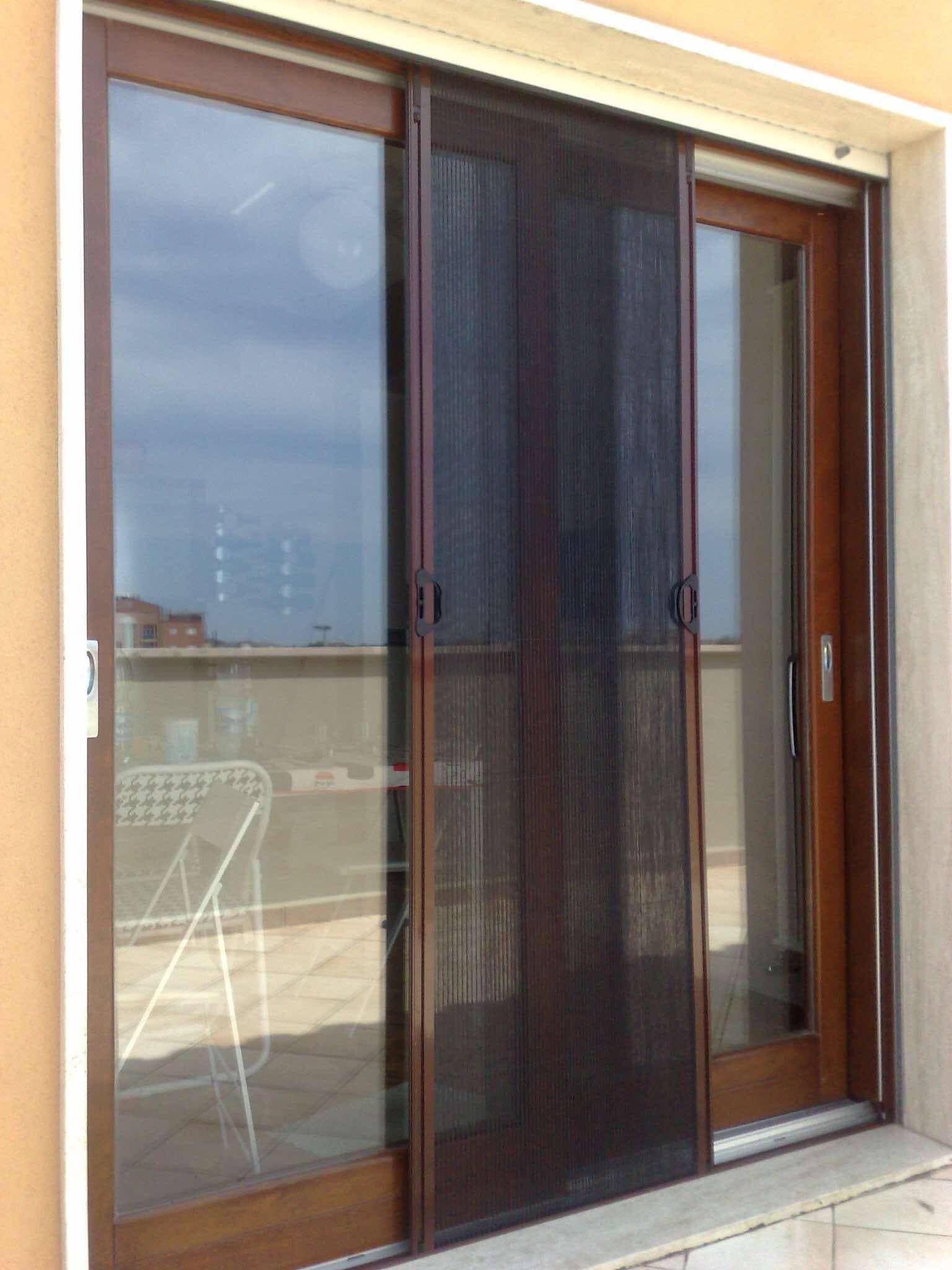 Una porta scorrevole in vetro con una zanzariera