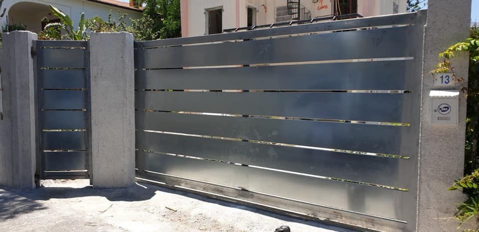 Un cancello scorrevole con una cassetta postale davanti