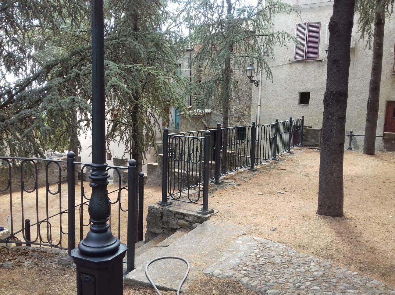 Un'area recintata con alberi e un edificio sullo sfondo