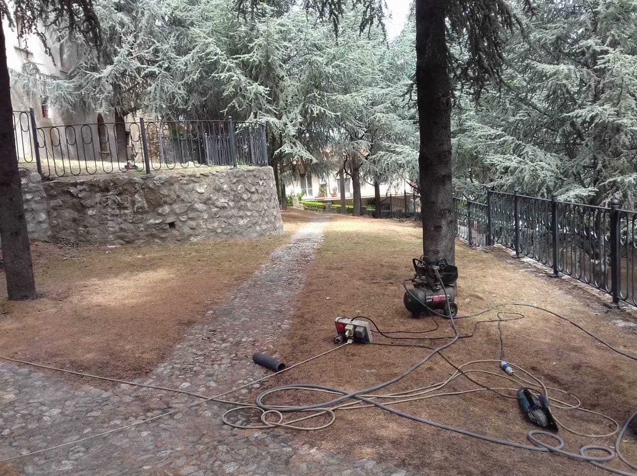 Una motocicletta è parcheggiata in mezzo a un parco, accanto a una recinzione.