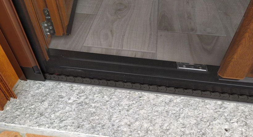 Primo piano di una porta scorrevole su un pavimento in marmo.