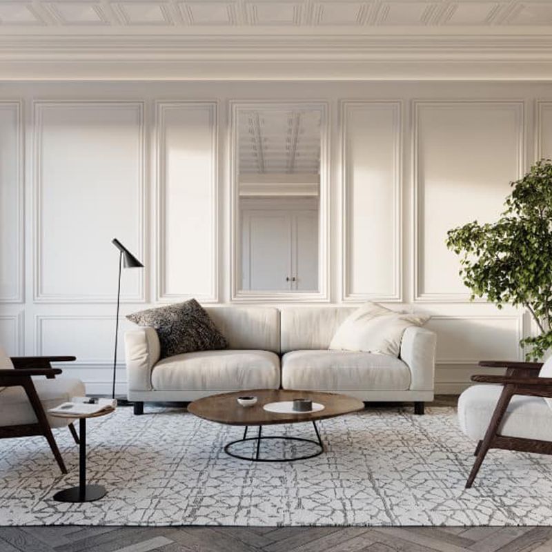 Un soggiorno con divano, sedie, tavolino e tappeto.