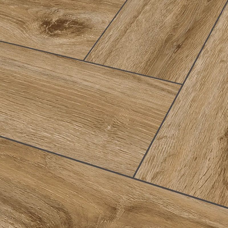 Primo piano di un pavimento in legno con motivo a spina di pesce.