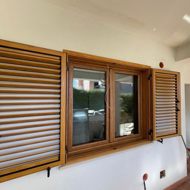 Una finestra con persiane di legno su un muro bianco