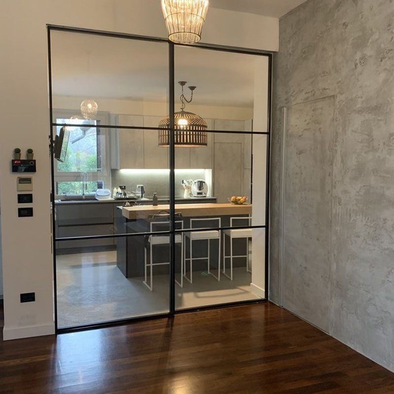 Una stanza con una porta scorrevole in vetro che conduce alla cucina.