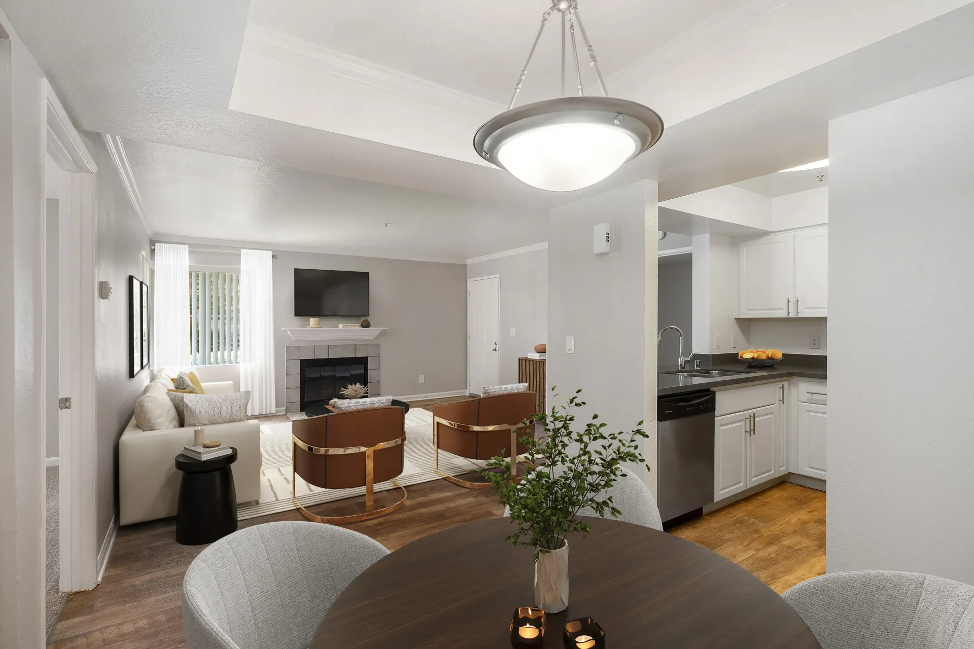 Open-concept living area with a sofa, fireplace, and view into the kitchen.