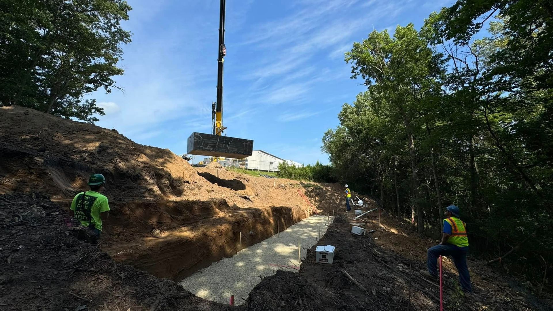 A crane is lifting a large piece of concrete into the air.