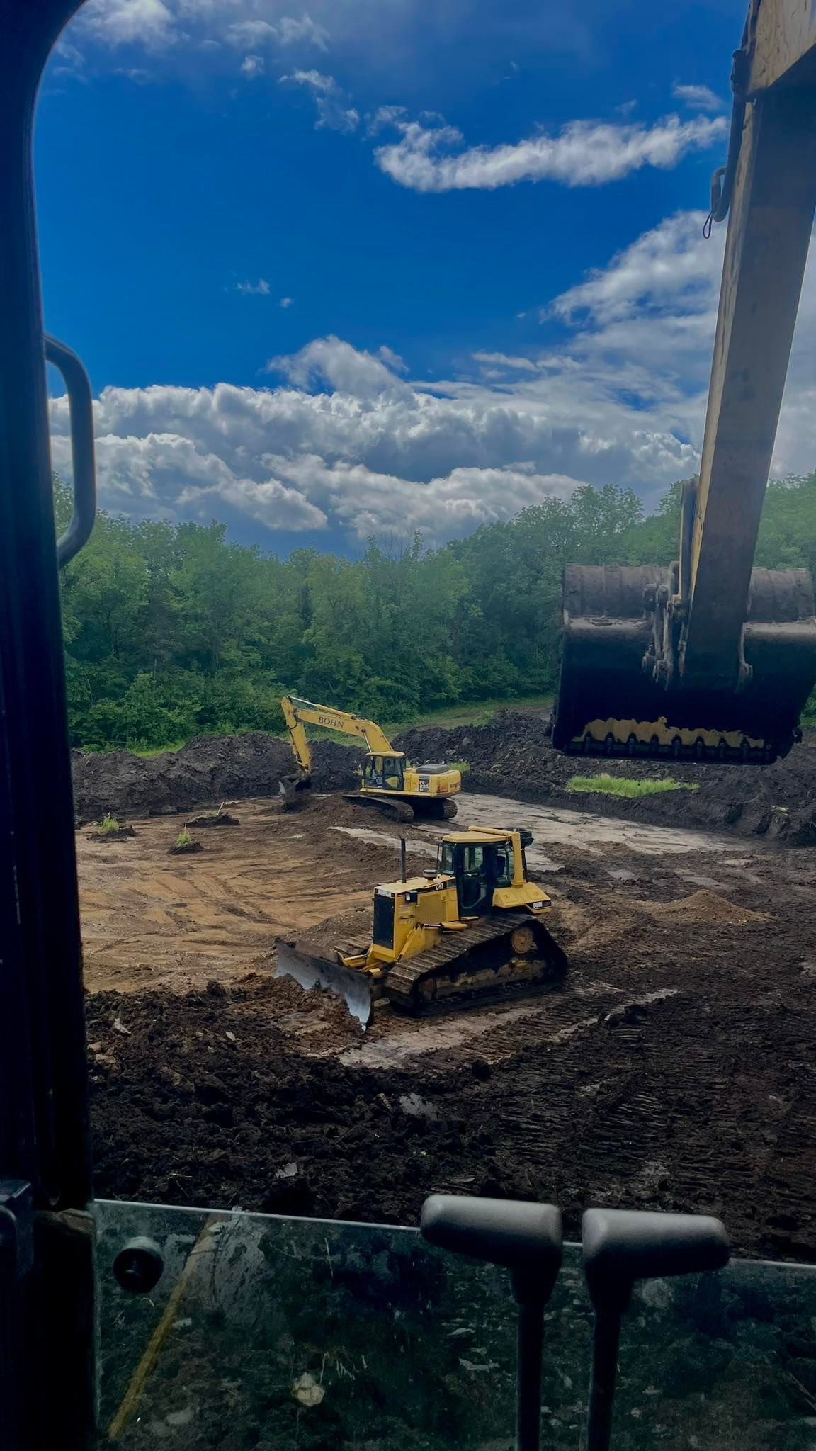 A view of a construction site from inside a bulldozer.
