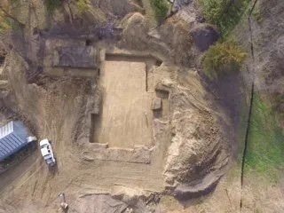 An aerial view of a house being built in the middle of a dirt field.