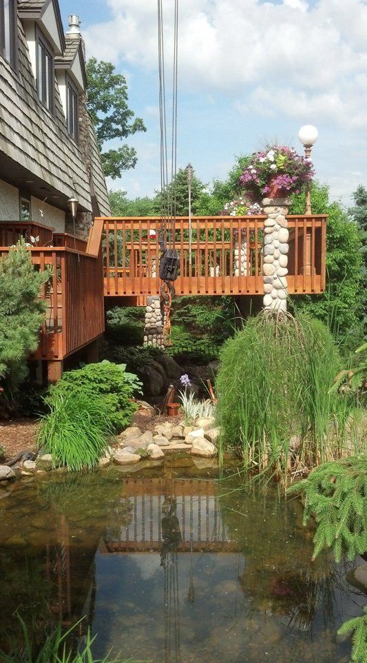 A wooden bridge over a pond in front of a building