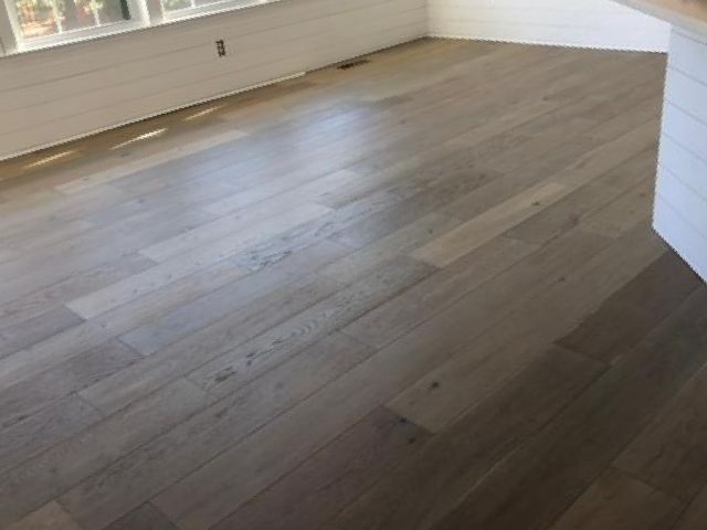 A living room with hardwood floors and a window.