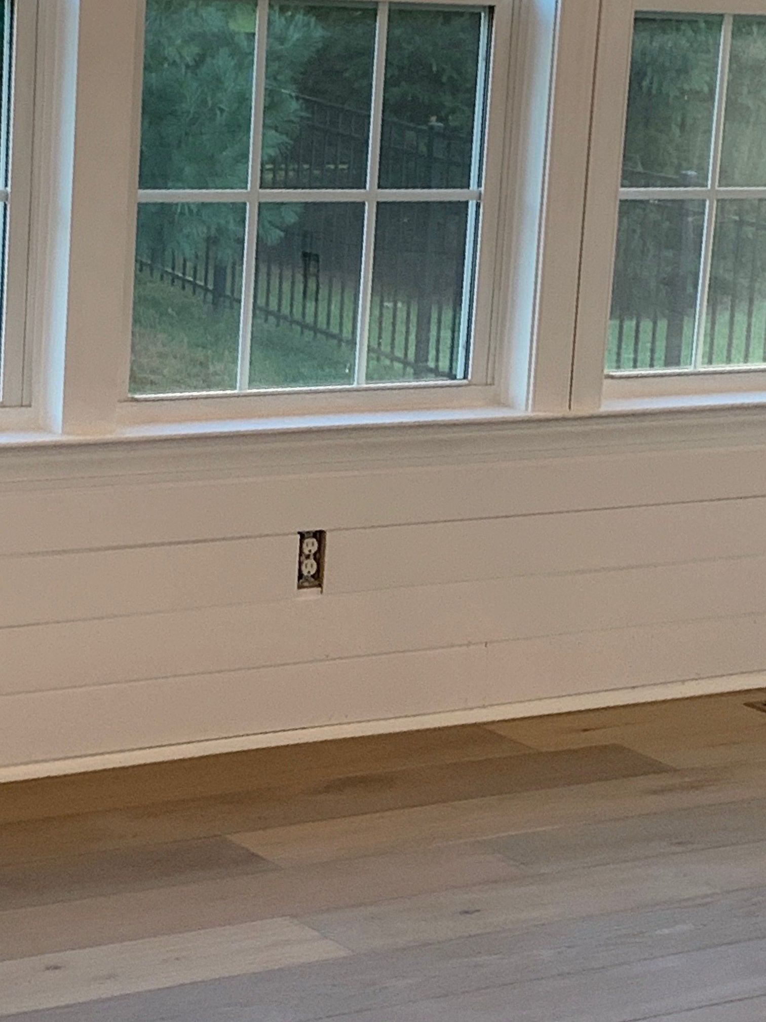 A room with a lot of windows and a wooden floor.