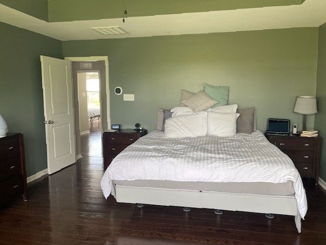 A bedroom with a large bed and a dresser