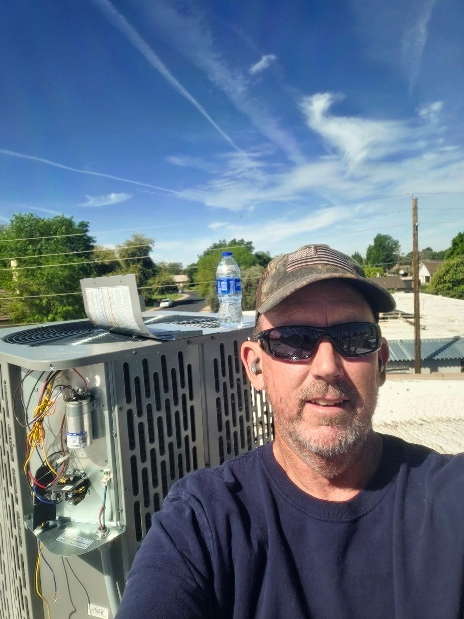 Two air conditioners are sitting on the side of a building.