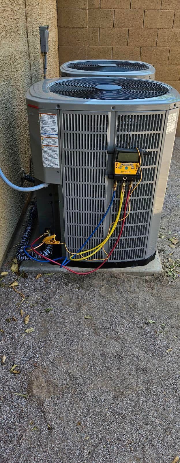 A couple of air conditioners are sitting next to each other on the side of a building.