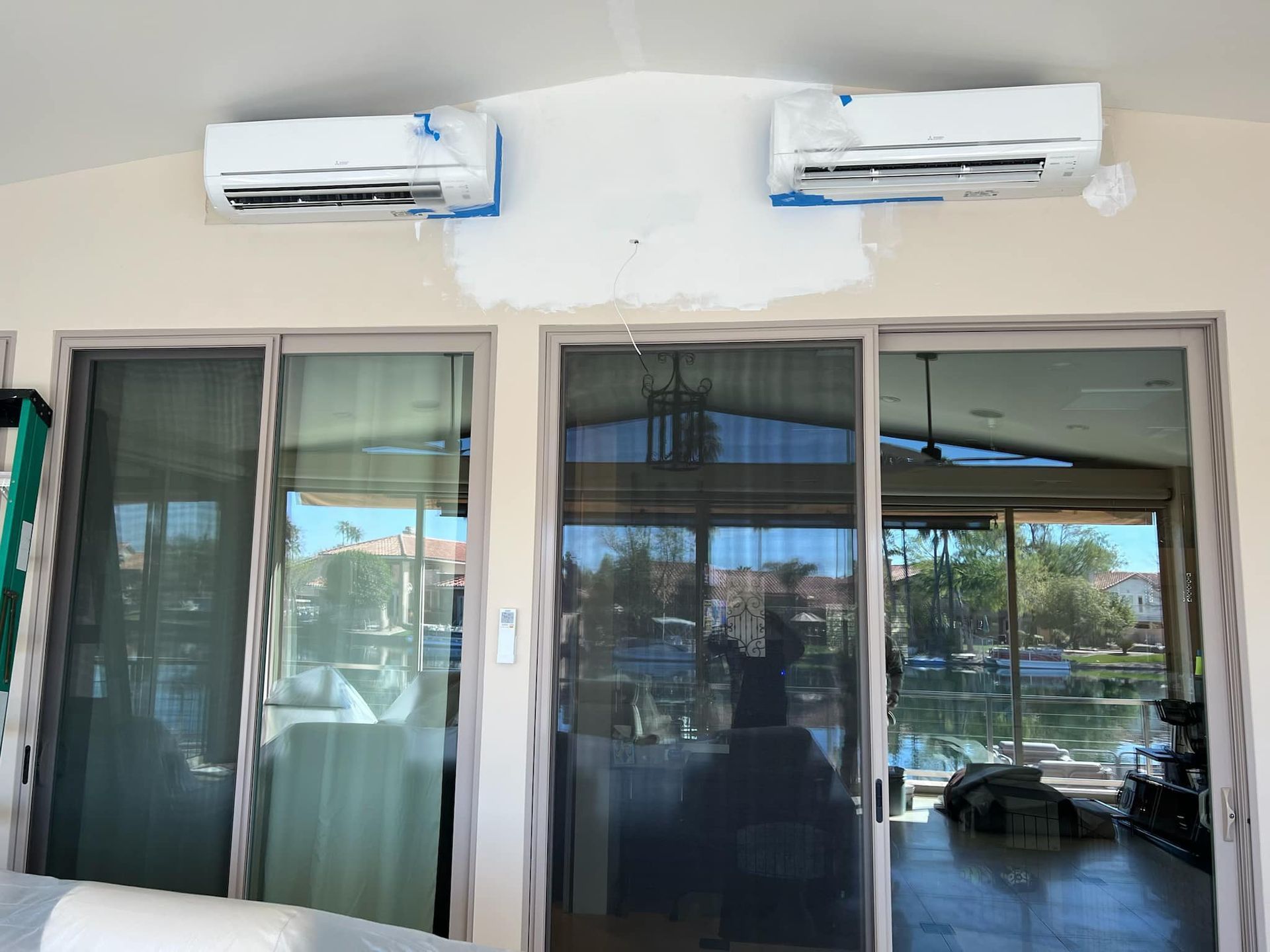 Two air conditioners are hanging from the ceiling of a house.