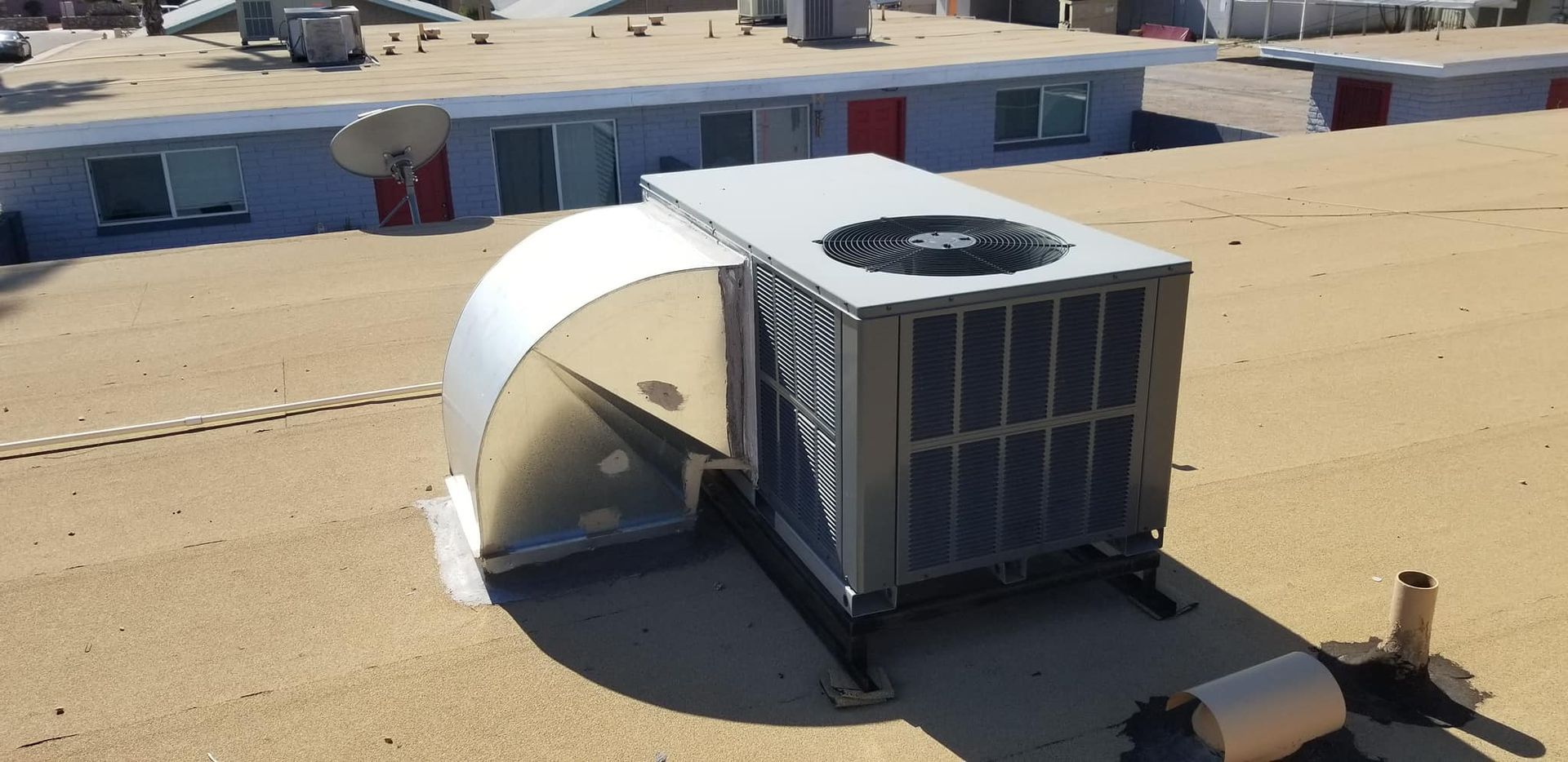 A large air conditioner is on the roof of a building