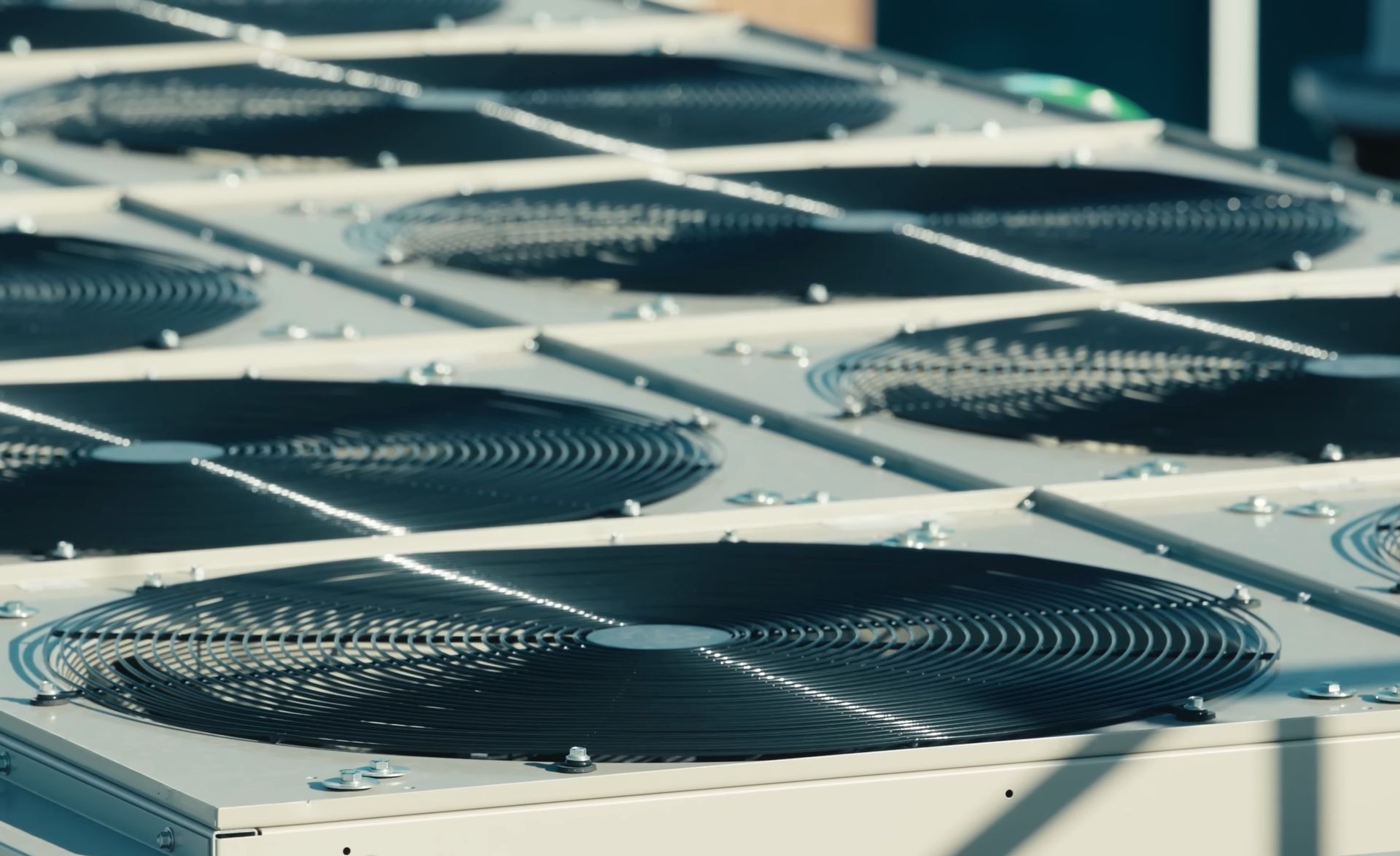 A close-up view of several black industrial ventilation fans mounted on a flat grey rooftop.