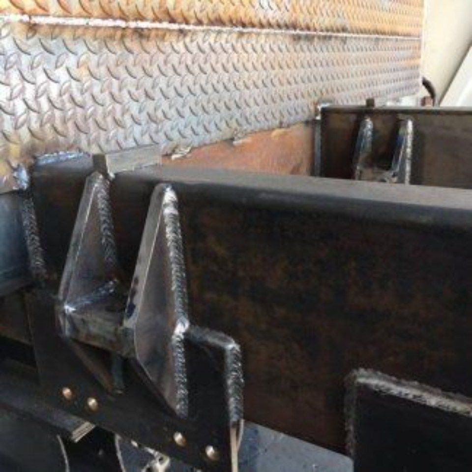 A close up of a metal structure with a metal wall in the background.