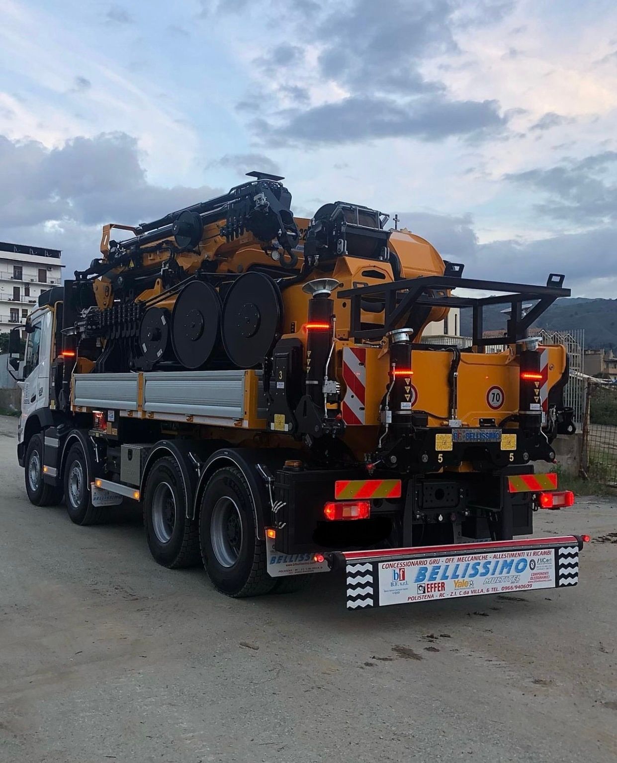 A large yellow truck with a sign on the back that says ' epilissimo '