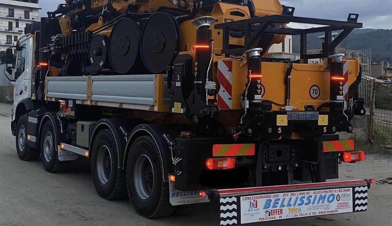 A large yellow truck is parked on the side of the road.