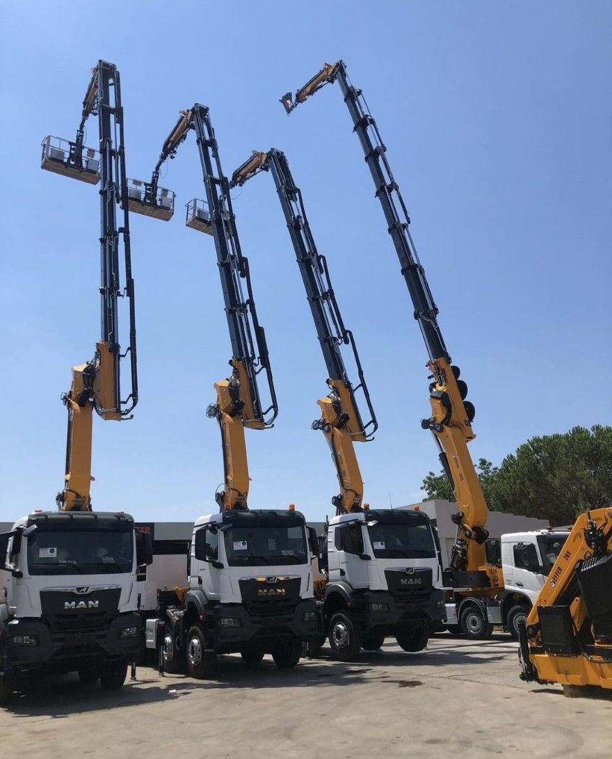 A row of man trucks are parked next to each other