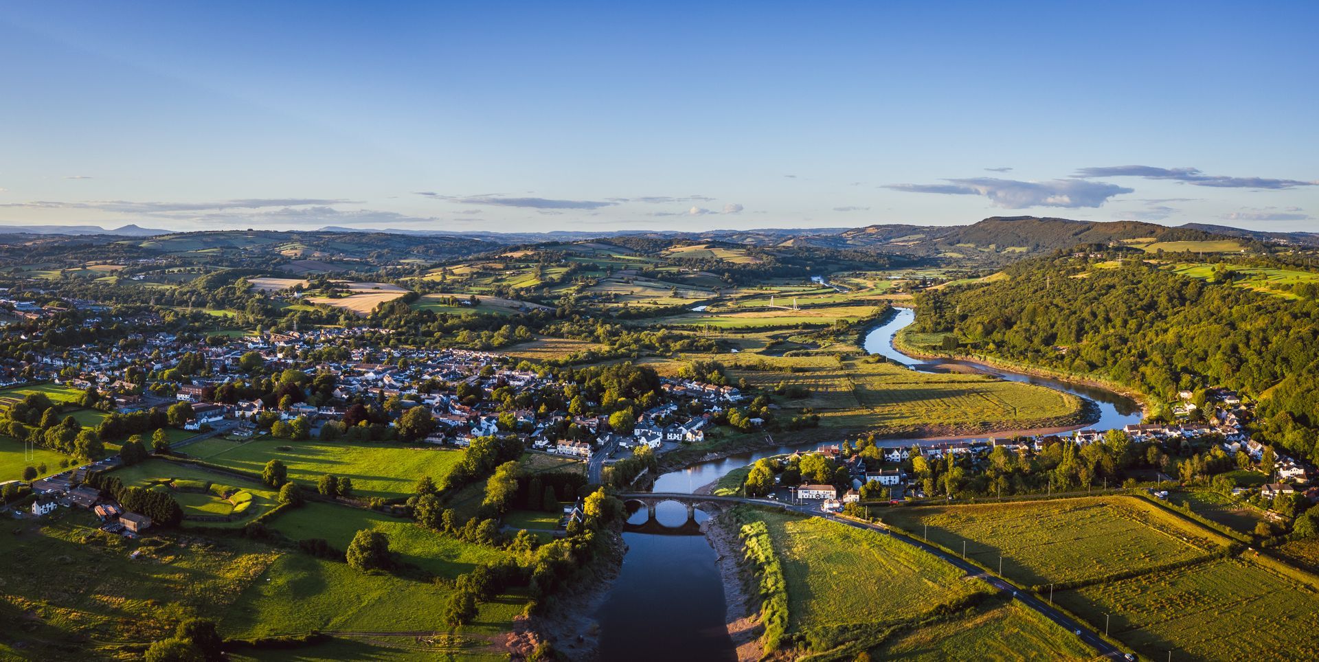 Aerial view of the River Usk Bridge and Caerleon Road leading into the Roman Village of Caerleon, Newport, Wales, United Kingdom. In the distance can be seen the Usk Valley and grounds of the Celtic Manor Resort.