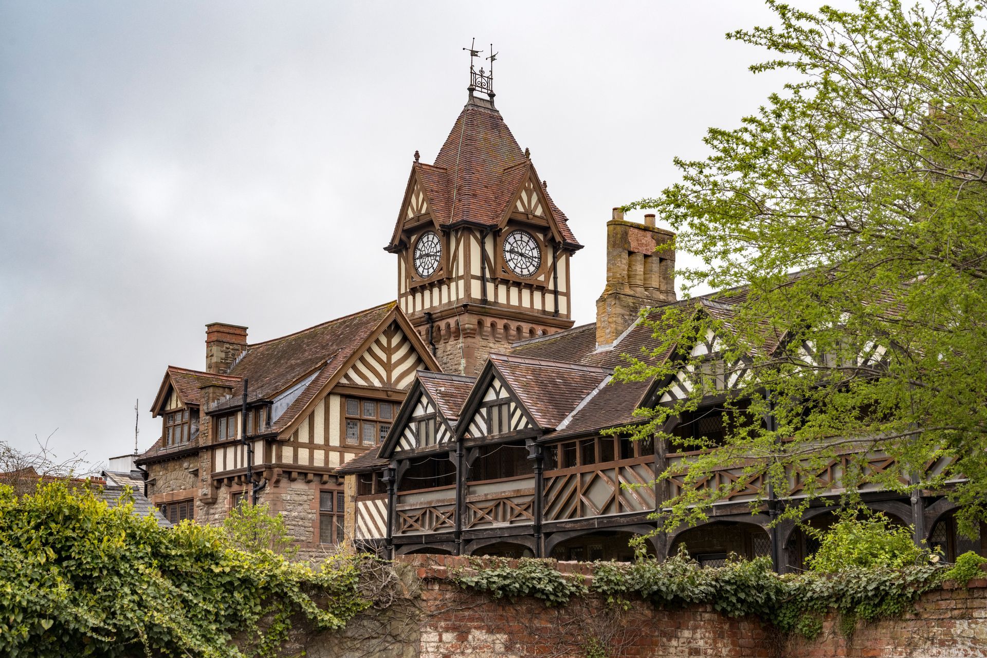 Image of the grand clock tower in Ledbury showing the Tudor design of timber and cream plaster wall sections amongst black and white Tudor period properties.