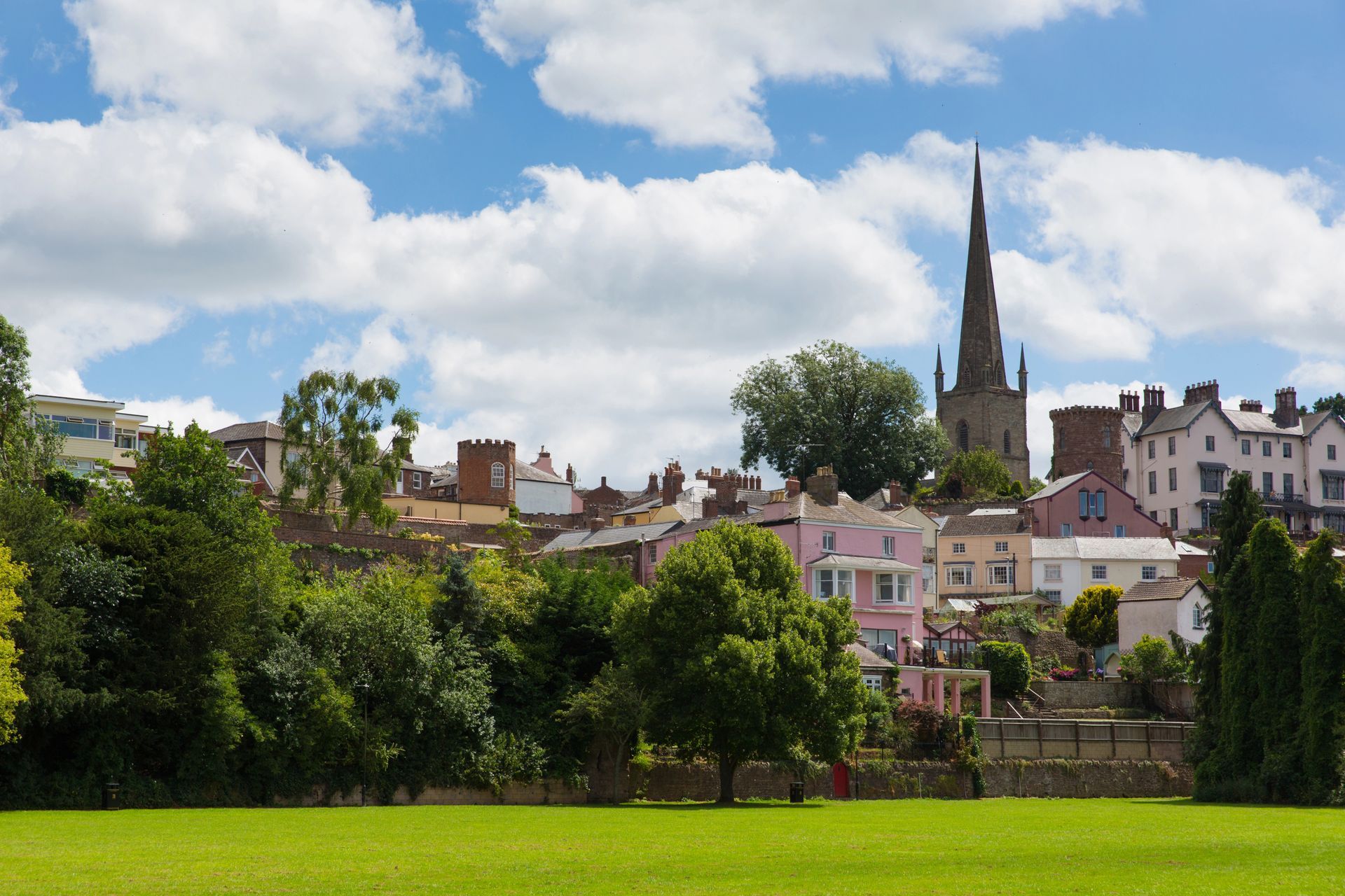 View of the historic Gloucestershire town of Ross-on-Wye with pretty coloured houses and properties, and the St Mary's Parish Church in the background. 