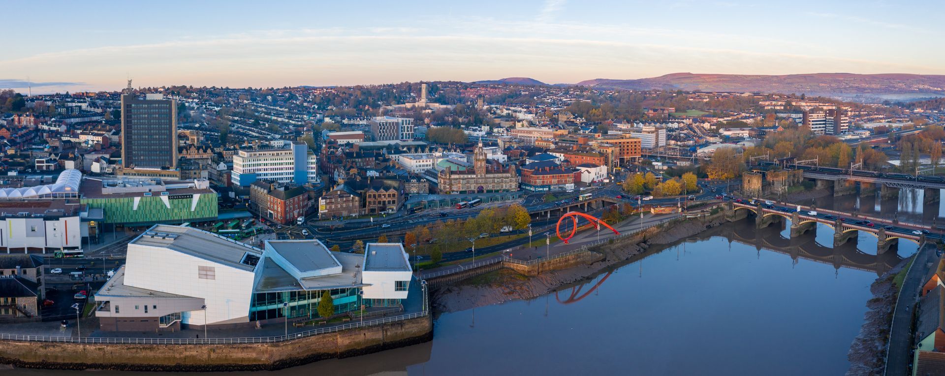Aerial view of the City of Newport and its city centre including the upper bus station and the Civic Centre in the background with the Turner Clock Tower visible, Newport, Wales, United Kingdom. The Riverside Theatre and River Usk are in the foreground.