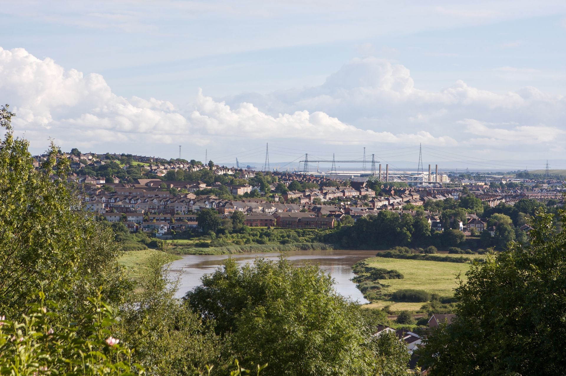 Long range view from a Caerleon hillside towards the River Severn in the far distance. Newport Transporter Bridge and Newport Docks can be seen with the River Usk flowing in the foreground.