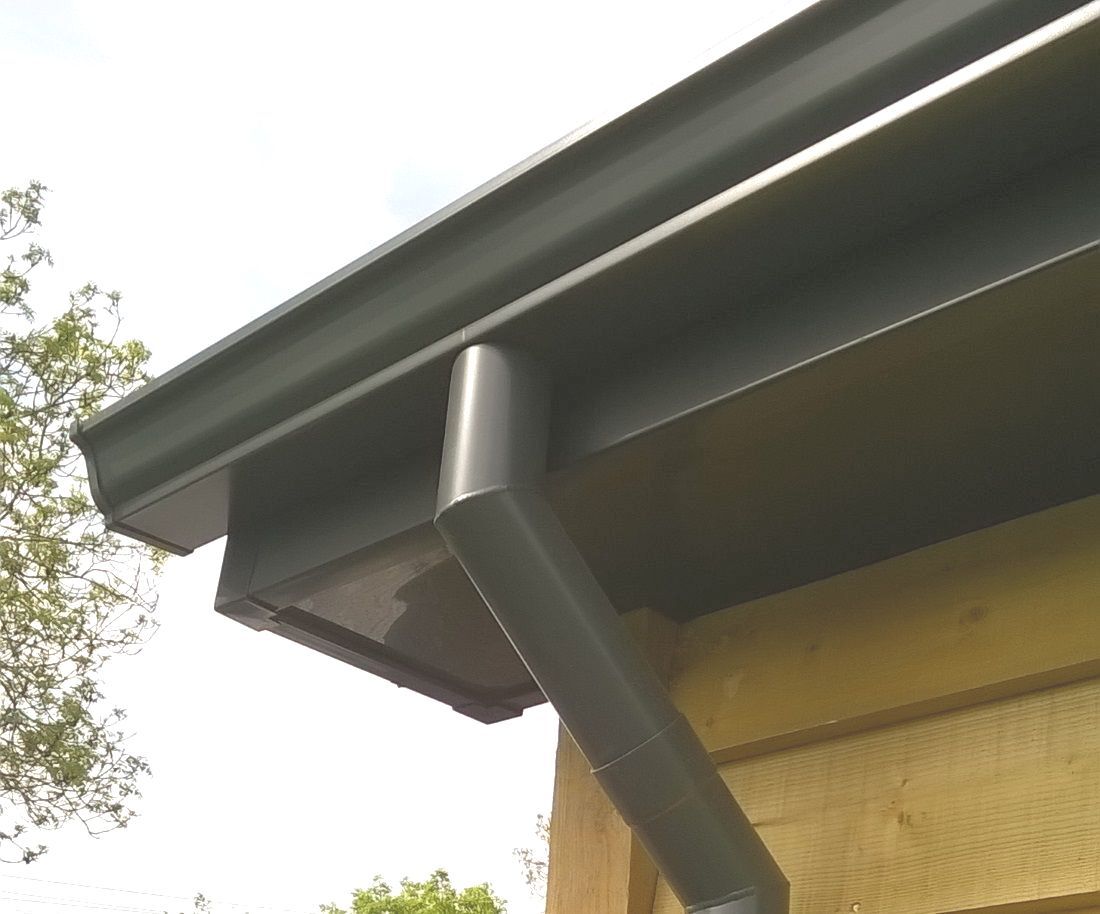 a seamless aluminium guttering system on a modern wooden cricket pavilion in the English countryside.