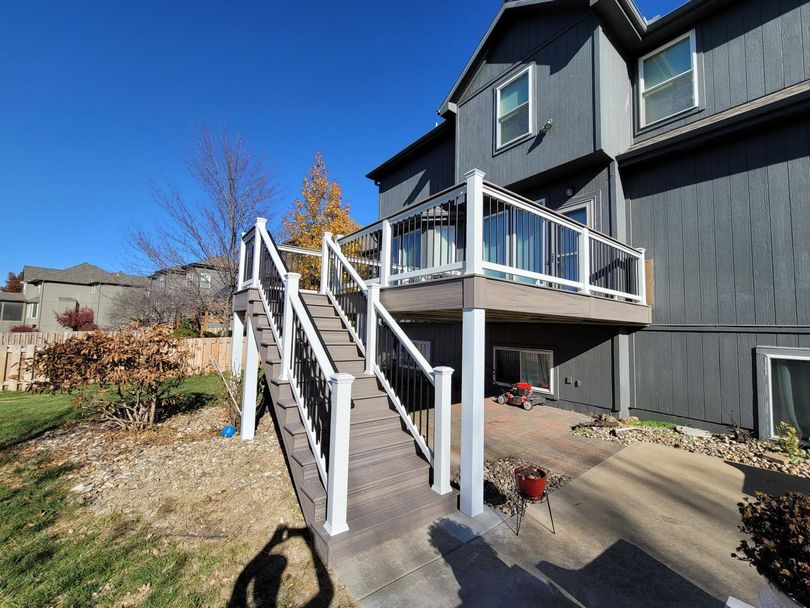 A large house with a large deck and stairs leading up to it.