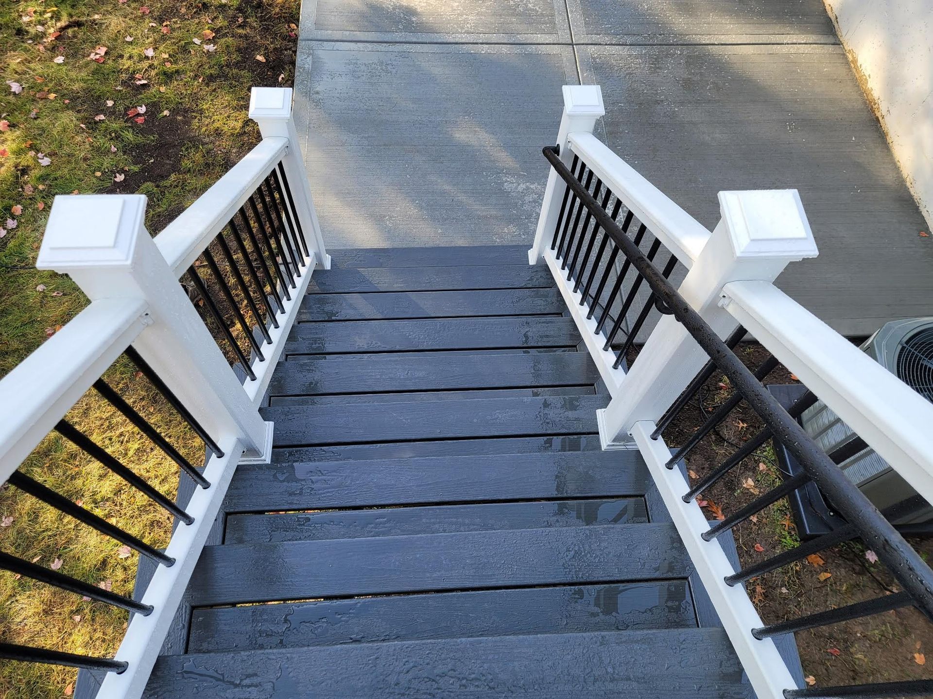 A set of stairs with a white railing and black railing