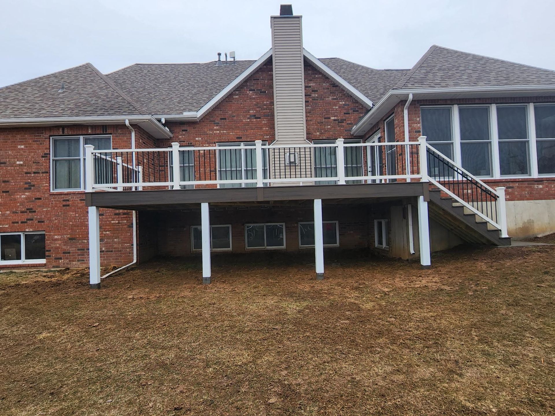 A large brick house with a large deck in front of it