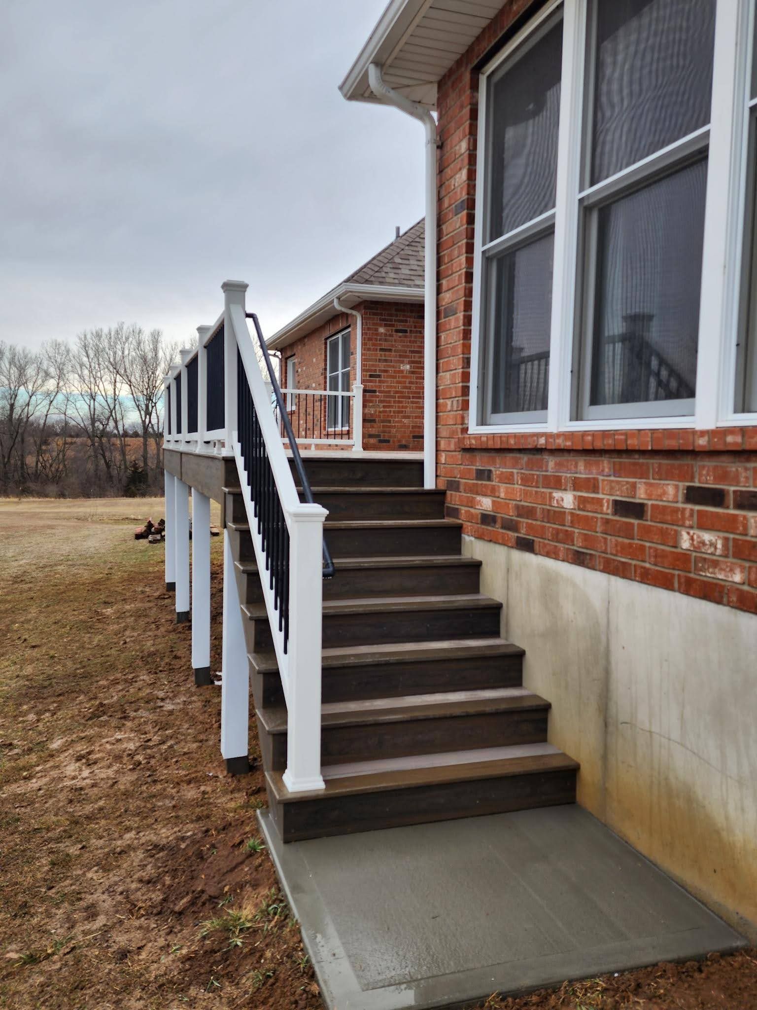 A house with a deck and stairs leading up to it.