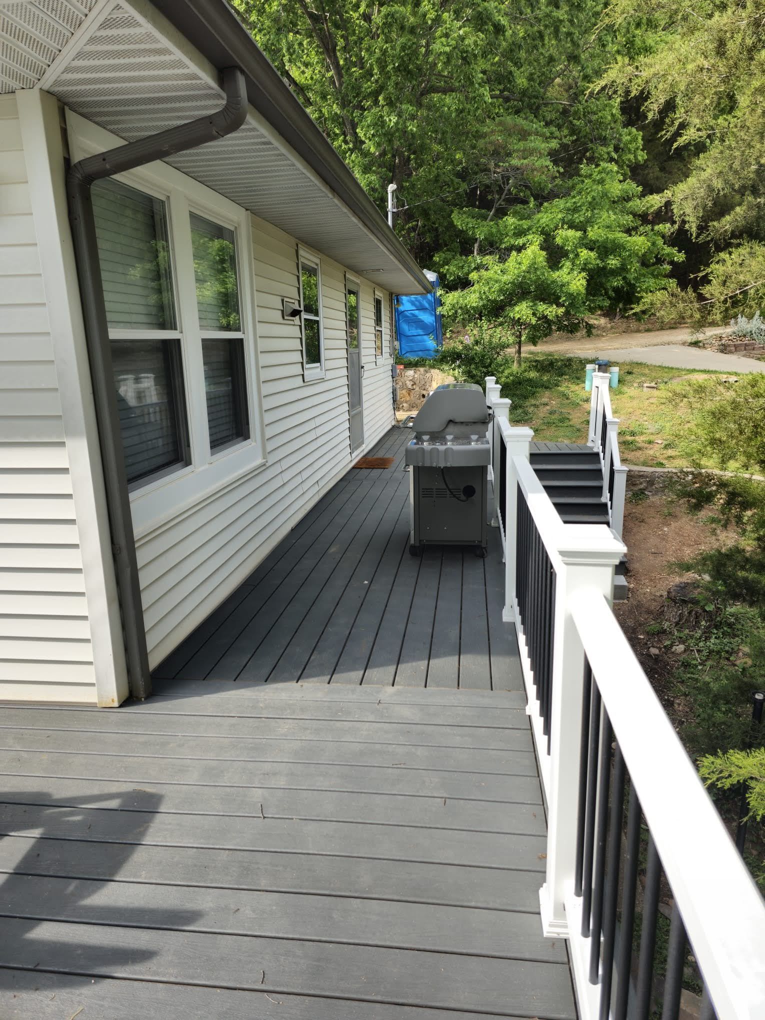 There is a grill on the deck of a house.