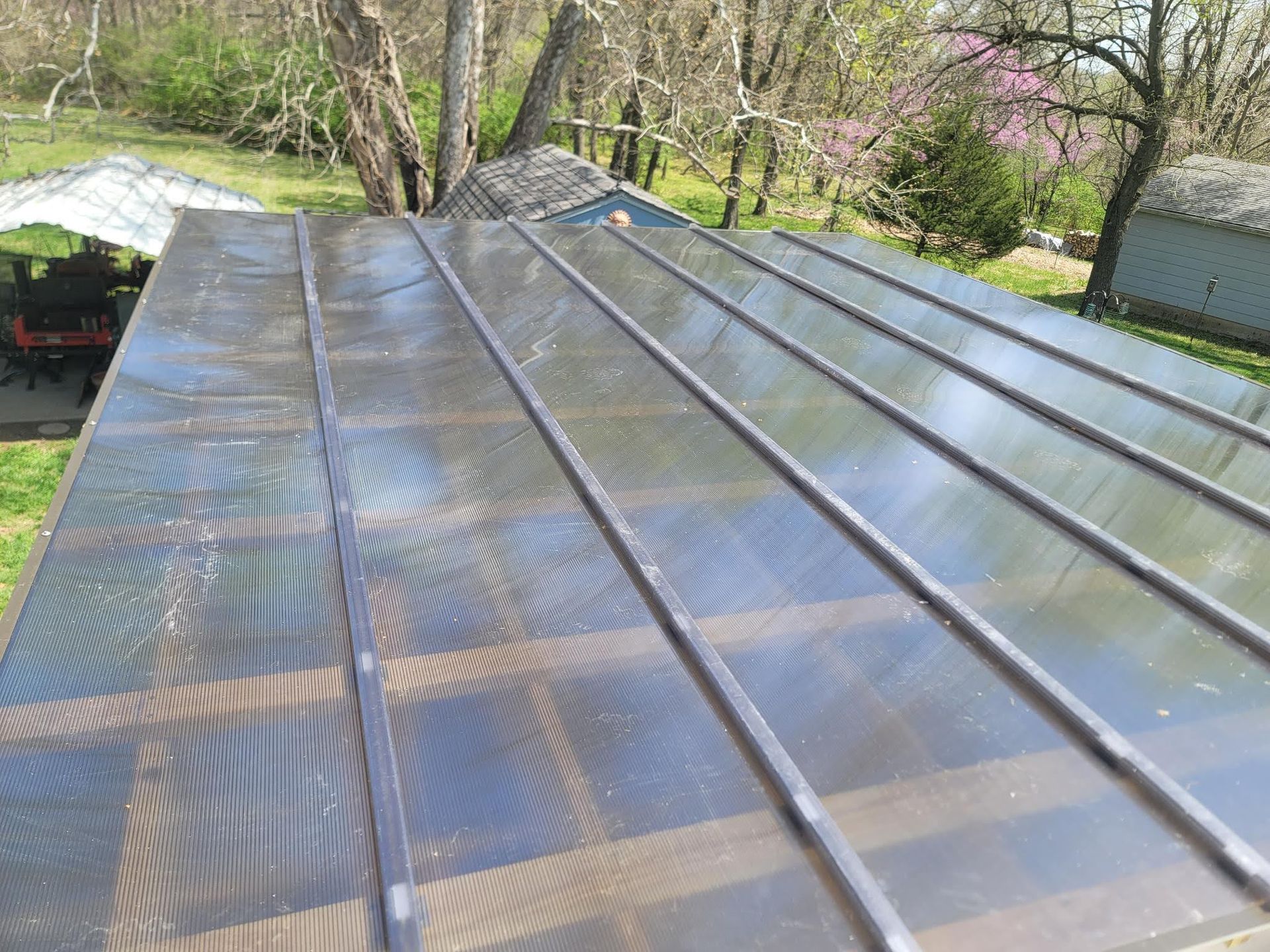 A roof with a lot of lines on it and trees in the background.