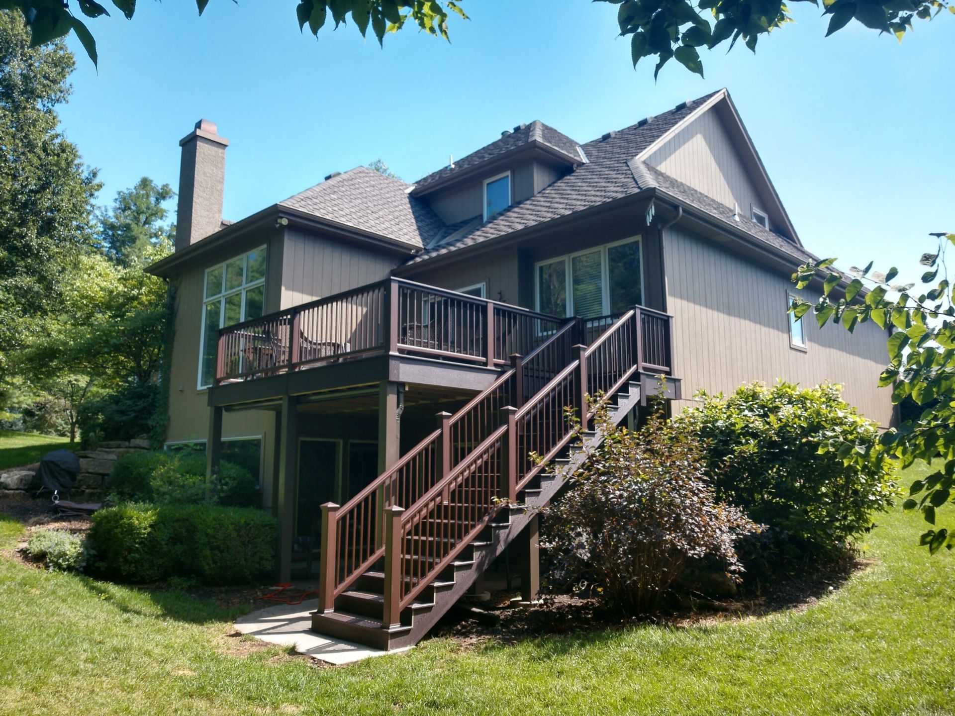 A large house with a deck and stairs leading up to it