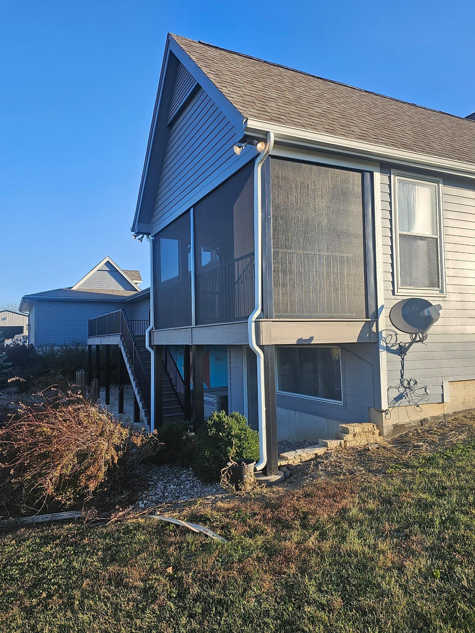 A house with a screened in porch on the side of it.