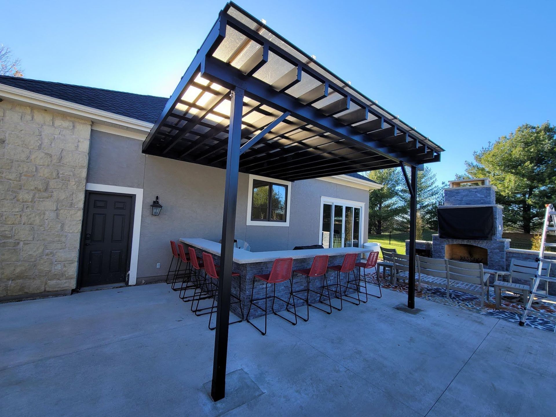 A patio with a table and chairs under a pergola.