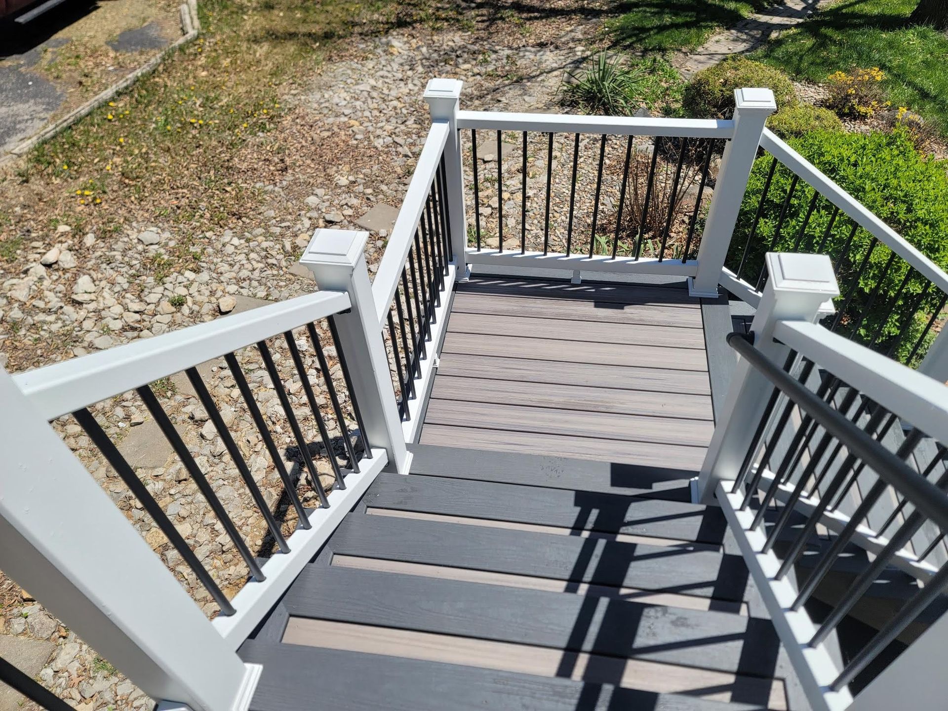 A set of stairs leading up to a deck with a white railing