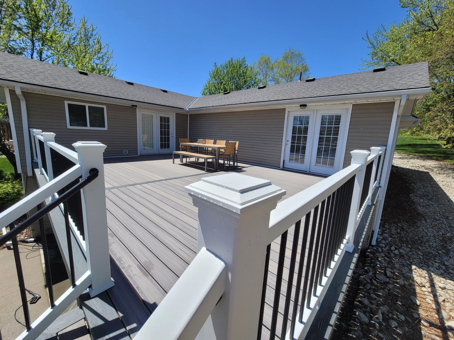 There is a large deck with a table and chairs on it.