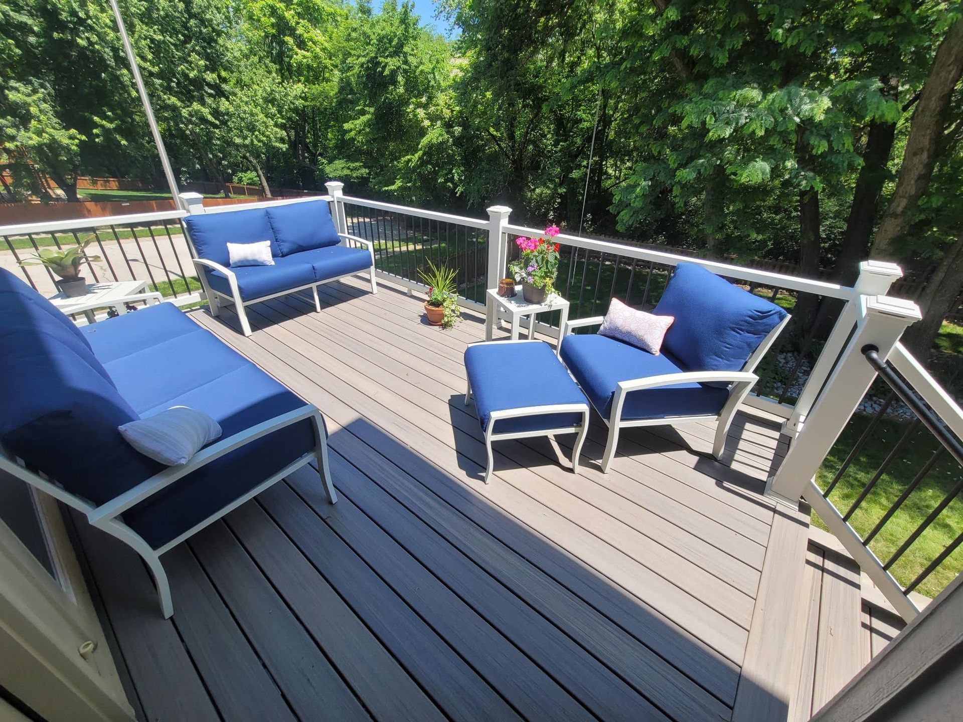 A deck with blue chairs and a couch on it