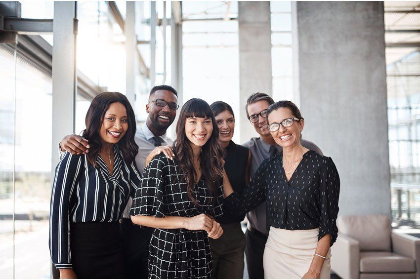 Group of friendly businesspeople with male leader in front